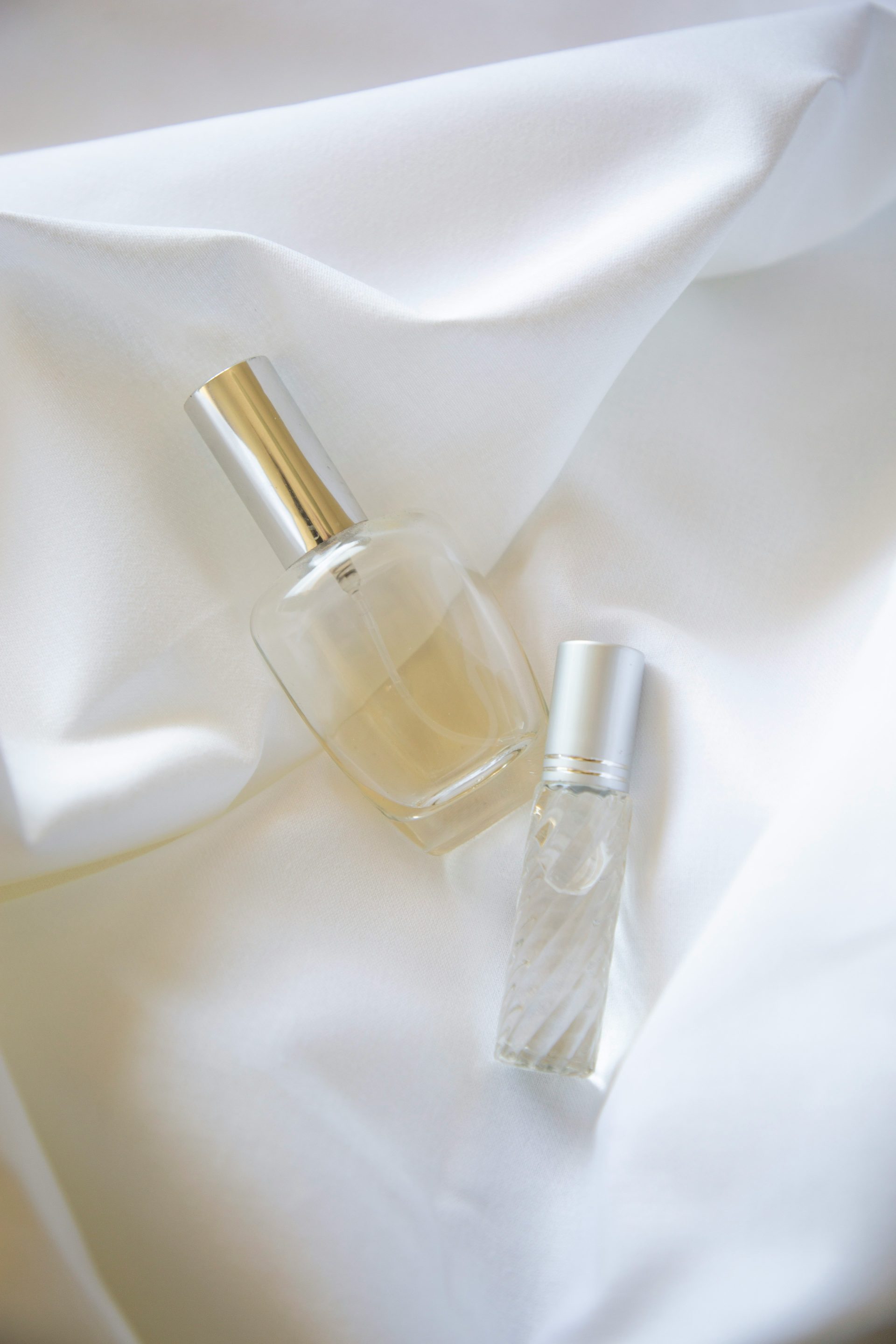 two bottles on white textile